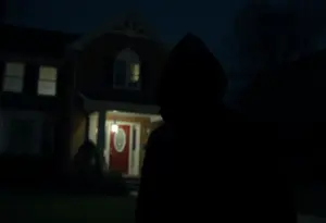 Masked armed suspect lurking near a residential house at night