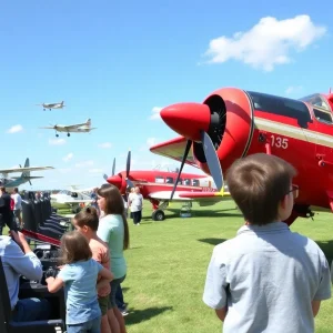 A crowd enjoying Bowman Fest at Bowman Field with vintage aircraft and flight simulators.