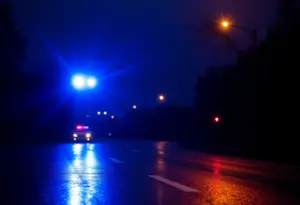 Wet road with police lights after a fatal accident in Jeffersontown