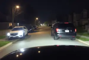 Dark suburban street in Louisville with vehicles
