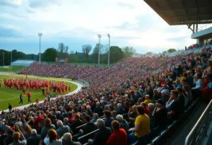 Crowd celebrating at a high school football game in Louisville, safety barriers in view.