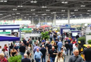 A busy trade show at Equip Exposition 2025 with attendees exploring landscaping innovations.
